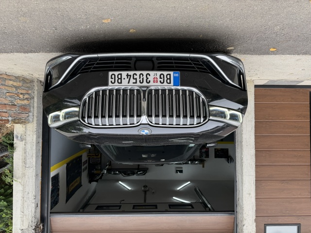 BMW sa uključenim dnevnim svetlima ispred radionice