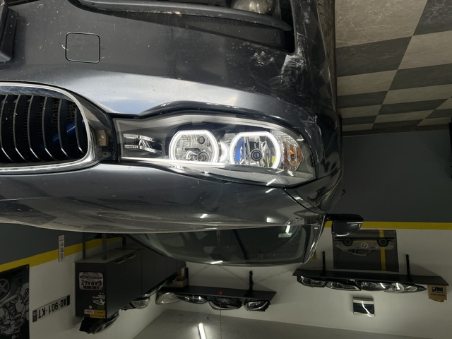BMW sa uključenim svetlima u radionici